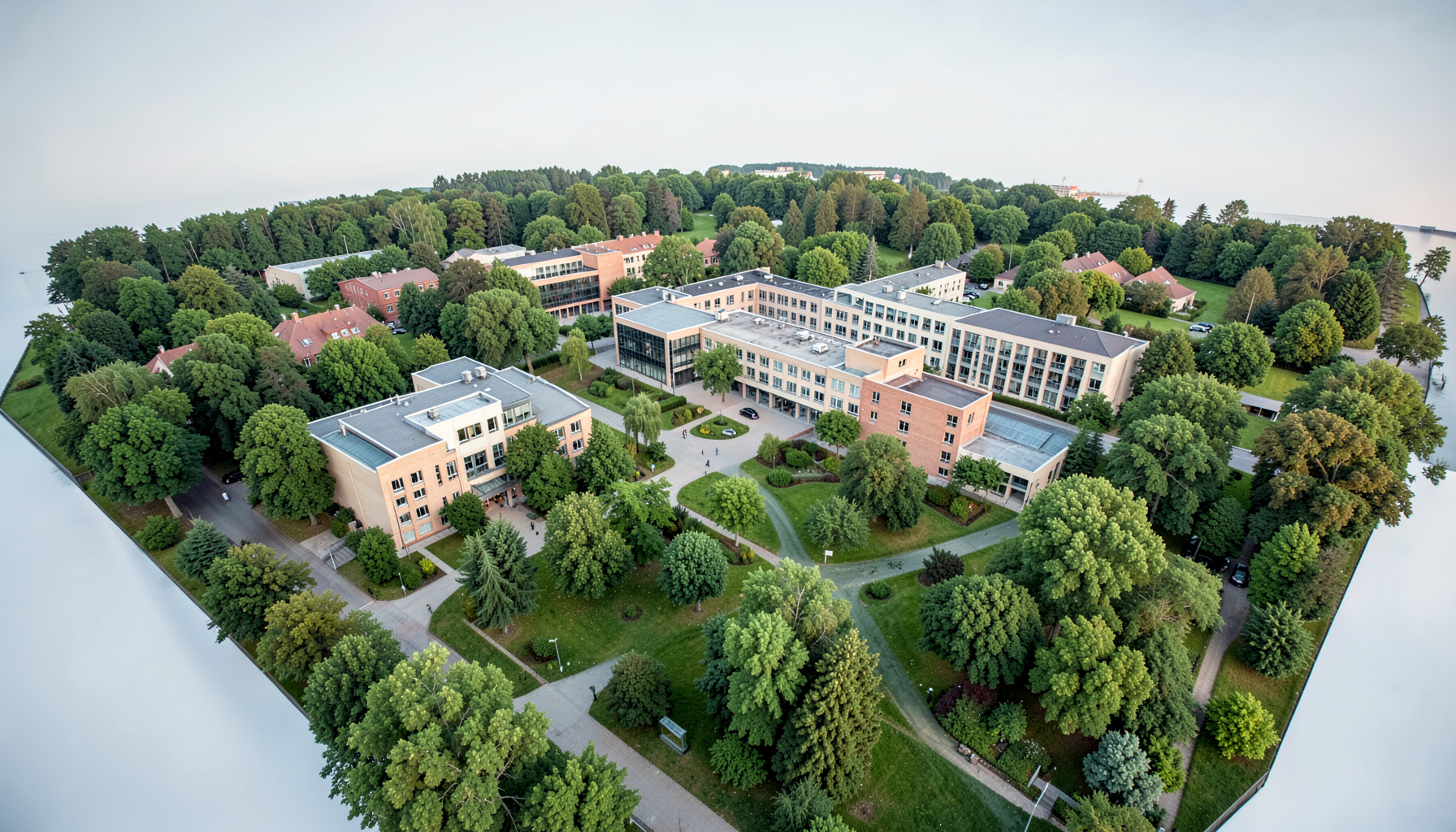 Aerial view of a modern university campus nestled in green parkland under soft Nordic light, calm academic atmosphere